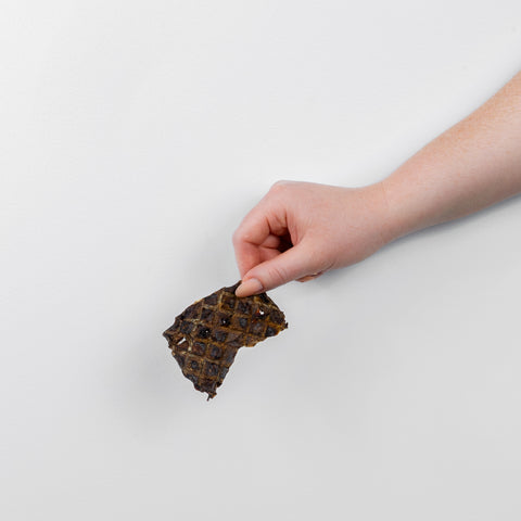 A piece of Lamb Lung Crisp held in hand
