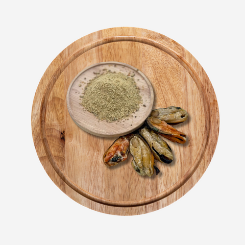 A round wooden chopping board holding a dish of nutritional booster powder alongside some Green-lipped Mussels