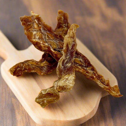 Pieces of Chicken Tenderloin Jerky on a chopping board