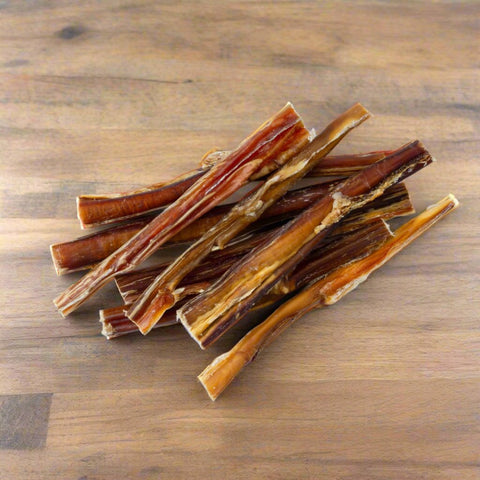 Thin Beef Pizzle dog treats on chopping board